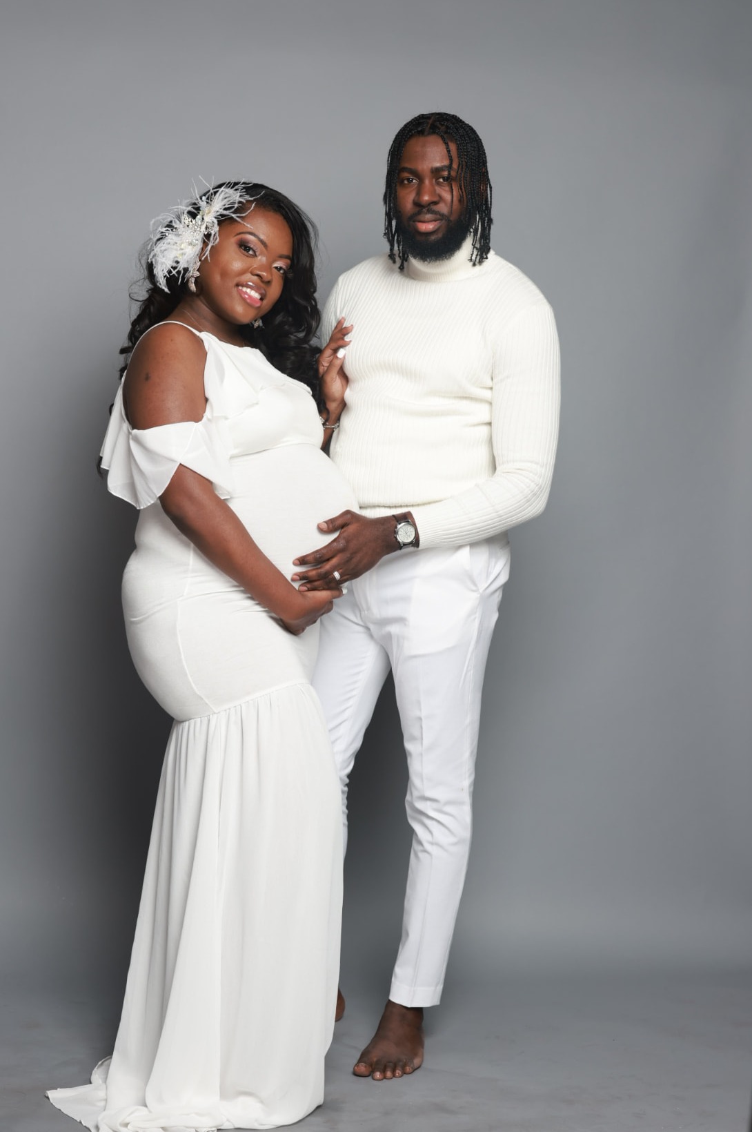 The founders — an expecting mother and her husband — in a soft studio maternity portrait