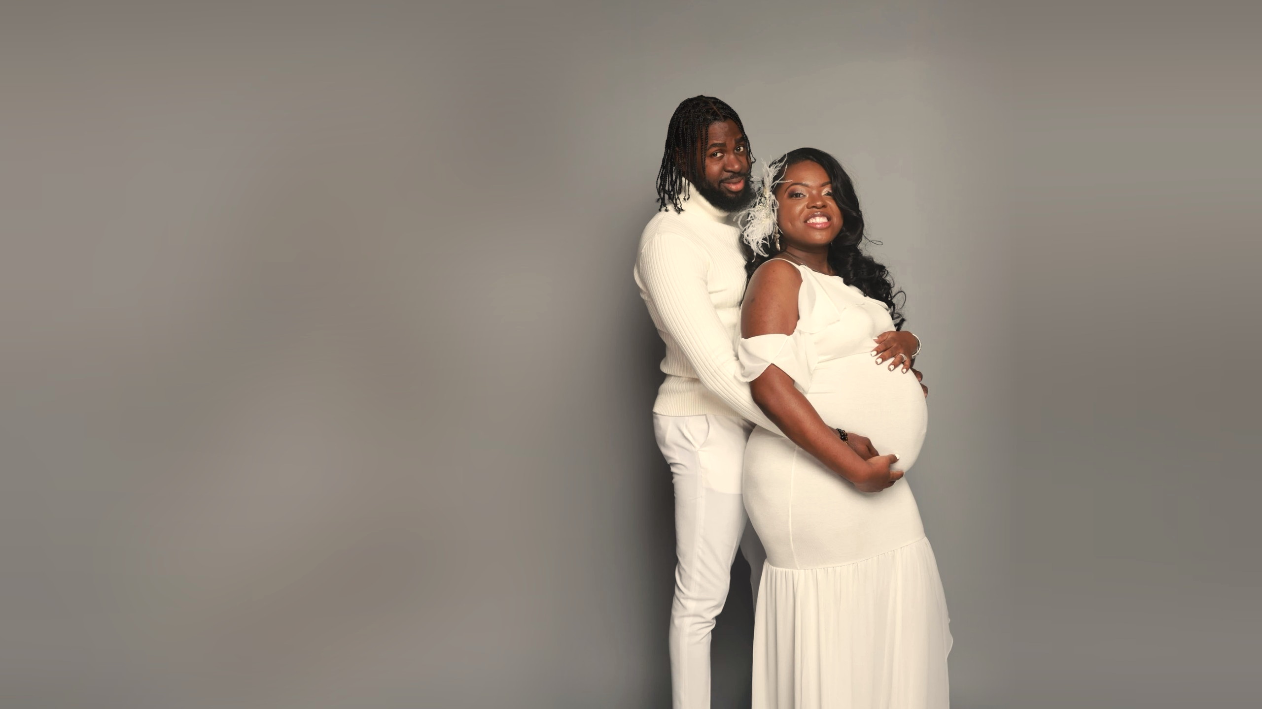 The founders — an expecting mother and her husband — in a soft studio maternity portrait